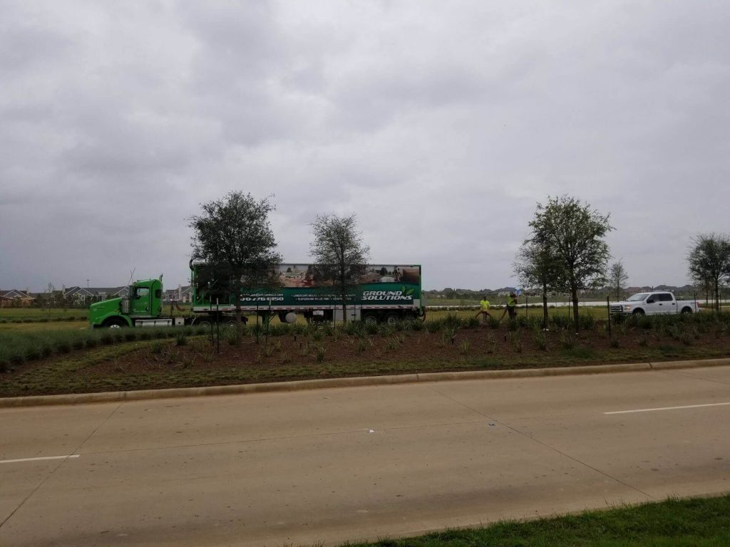 Ground Solutions blower truck placing early spring mulch landscaping in Texas