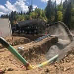 Bedrock slinger trucks backfilling with crusher fines around a natural gas pipeline in Colorado