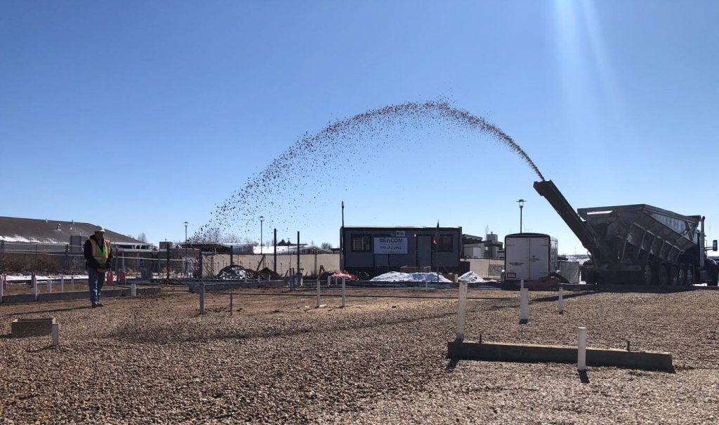 Bedrock’s Slinger Trucks placing draining gravel for concrete slab-on-grade preparation in Colorado