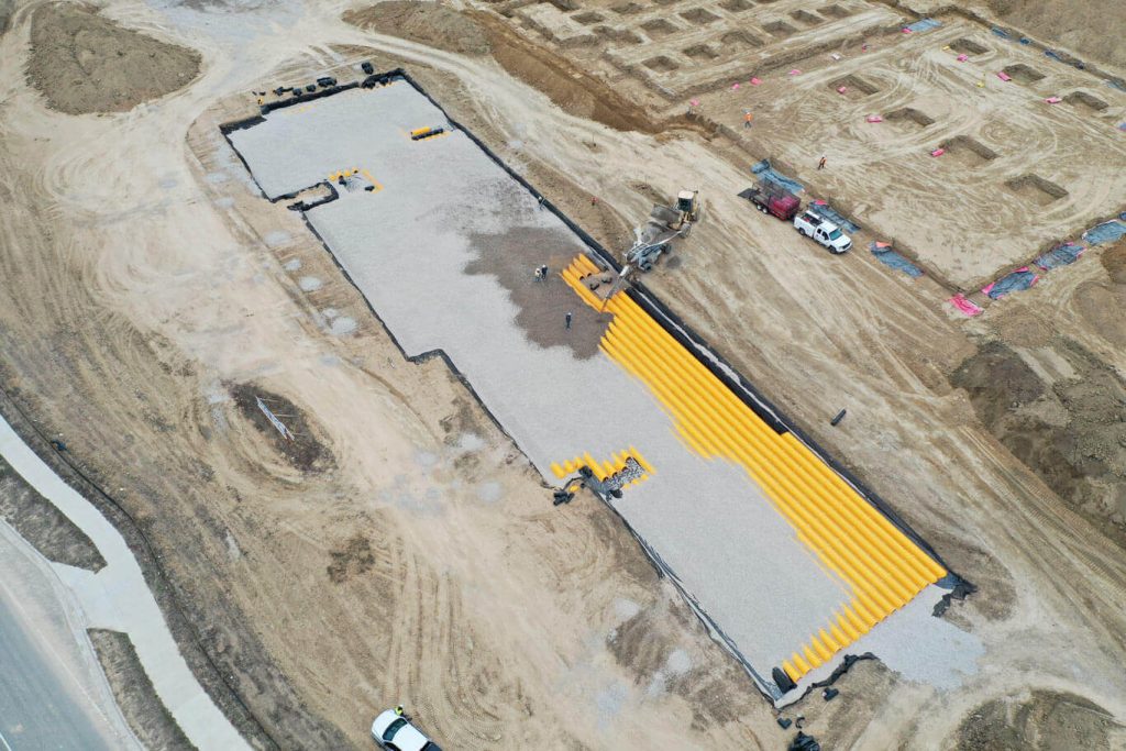 Bedrock's on-site stone slinger (OS7) placed crushed aggregate for backfill around StormTech system