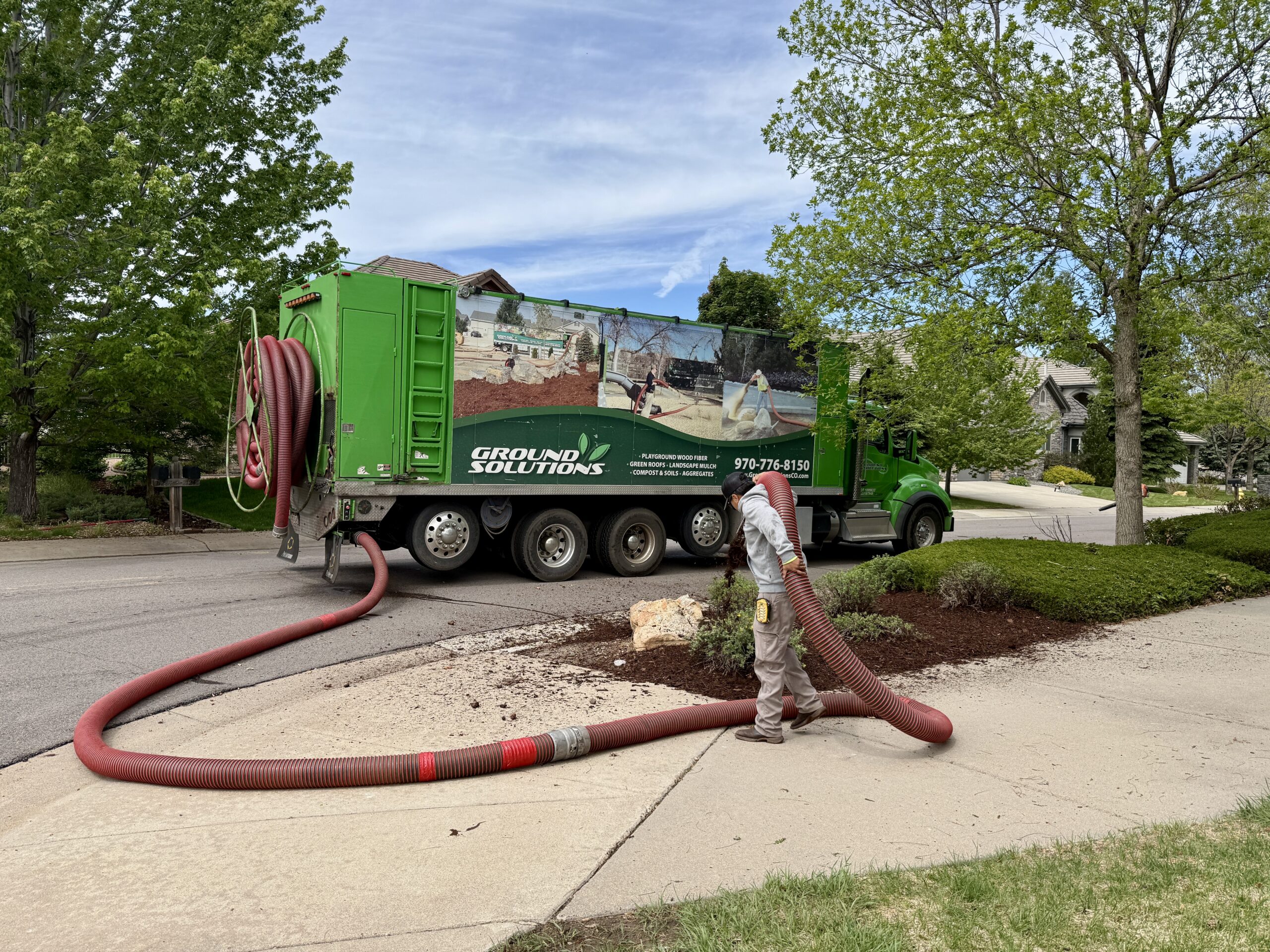 Blower spraying mulch to landscape
